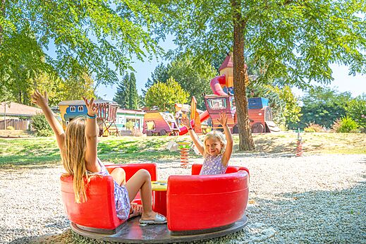 Fröhliche Kinder auf dem Spielplatz des Campingplatzes CAPFUN Temps Libre in BOUGE CHAMBALUD (38).