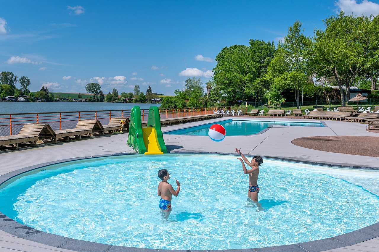 Au�enpool, Rutsche und spielende Kinder auf dem Campingplatz CAPFUN Tensch Jolie in Grostenquin (57).