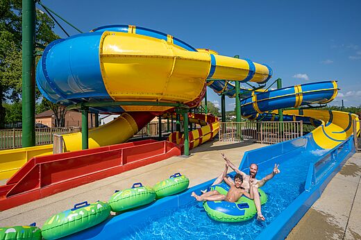 Bunte Wasserrutschen, Vater und Kind auf Campingplatz CAPFUN Tensch Jolie in Grostenquin.