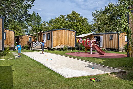 Petanquebaan met spelers en stacaravans op camping CAPFUN Teorix MARSEILLAN PLAGE.