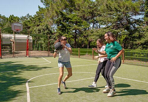 Frauen spielen Basketball auf Multisportplatz auf Camping CLICOCHIC Plage des Tonnelles in Saint-Jean-de-Monts (85).