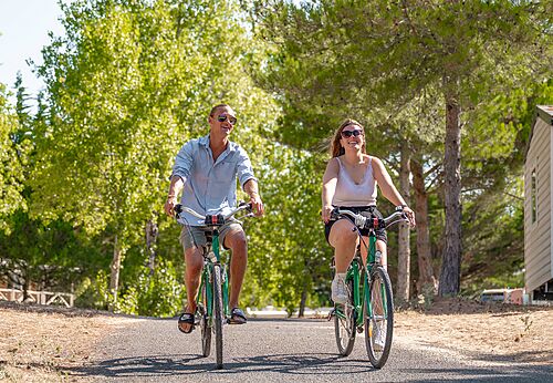 Paar fährt Fahrrad auf Allee auf Camping CLICOCHIC Plage des Tonnelles.
