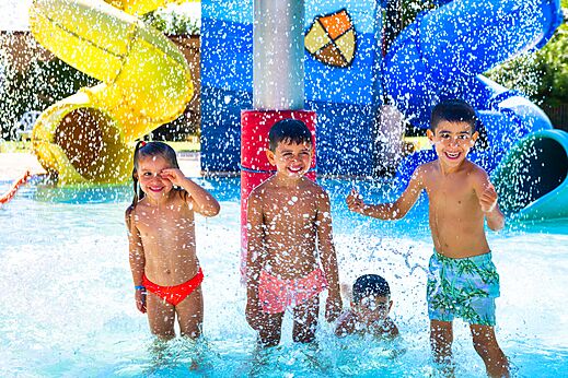Enfants souriants jouant dans l'aire de jeux aquatique avec toboggans au camping CAPFUN Tordera-Nacions � Malgrat de Mar (08).