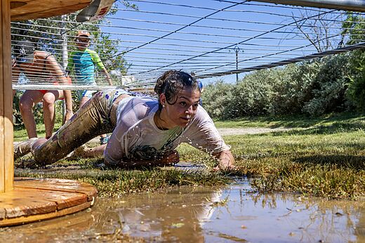 Parcours d'obstacles boueux, personne rampant au camping CAPFUN Tordera-Nacions � Malgrat de Mar.