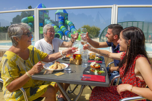 Famille au restaurant, toboggans, au camping CAPFUN Celeste à Breuillet (17).