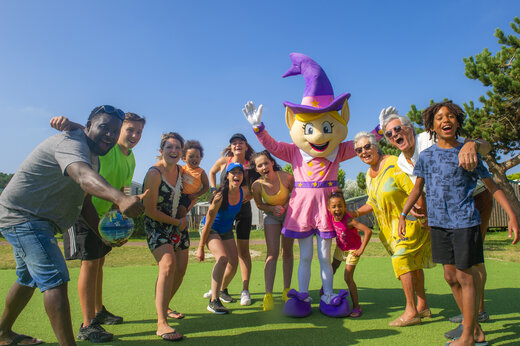 Groupe de vacanciers souriants avec la mascotte au camping CAPFUN Celeste à Breuillet (17).