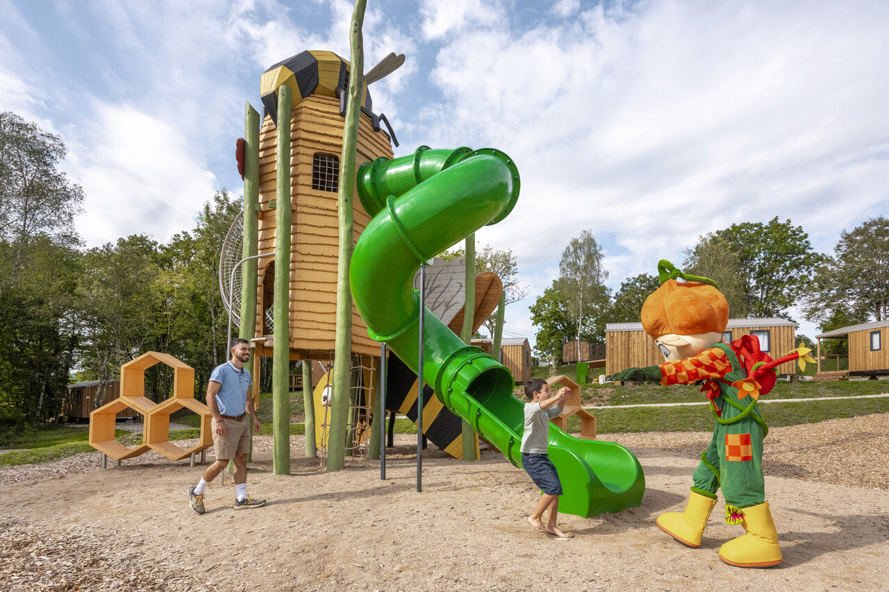 Themed playground with slide, child and mascot at CLICOCHIC Trelachaume campsite in Maisod (39).