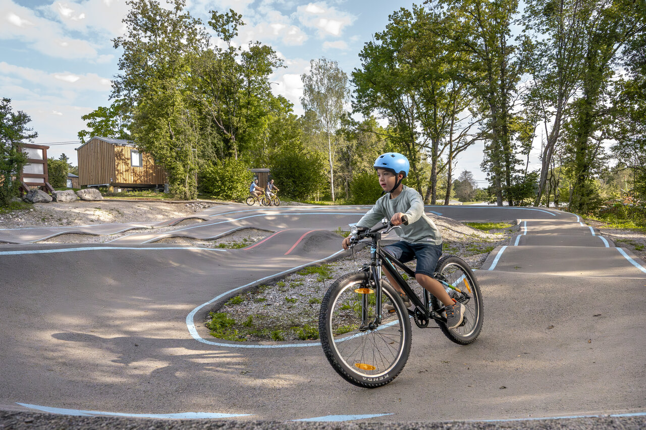 Child on bike on the pumptrack at CLICOCHIC Trelachaume campsite in Maisod (39).