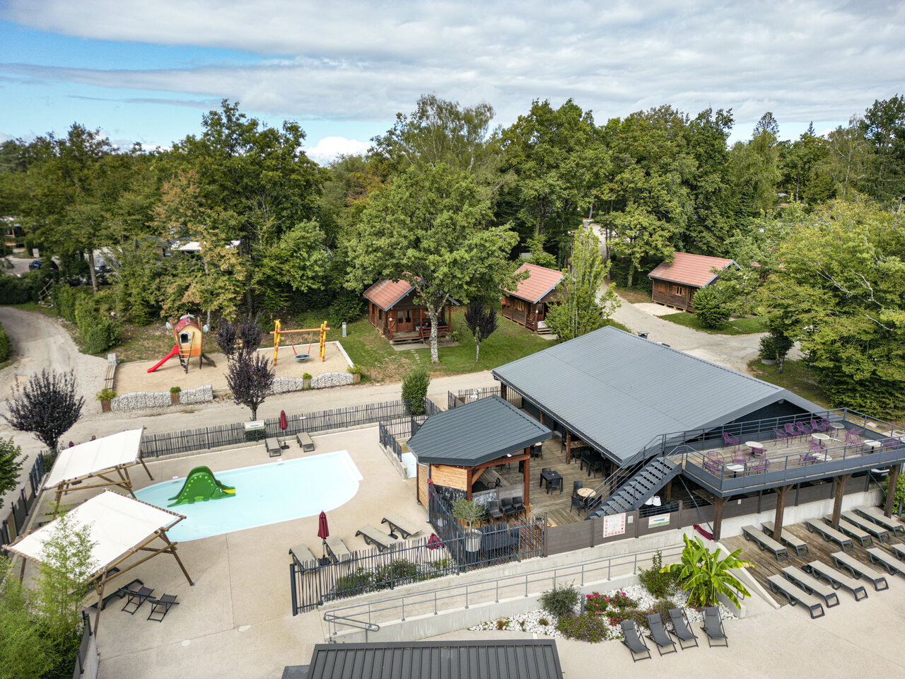Aerial view pool, restaurant and Mobile homes at CLICOCHIC Trelachaume campsite in Maisod (39).