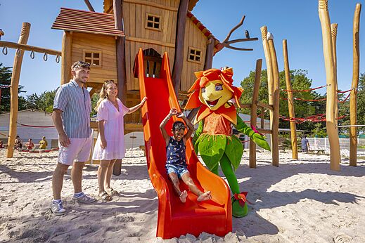 Spielplatz mit Rutsche, Kind und Maskottchen auf dem Campingplatz CLICOCHIC Trois Chênes.
