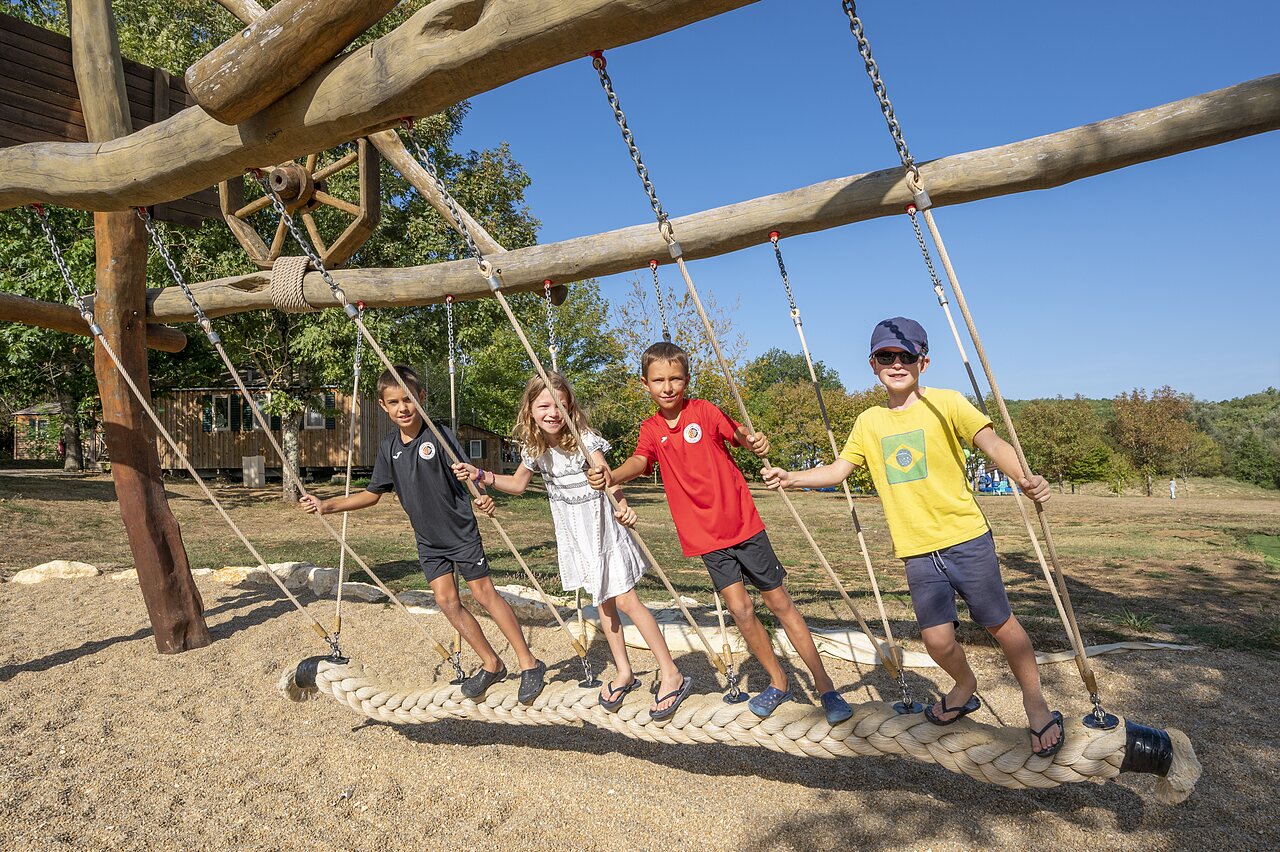 Children playing on giant wooden swing at CAPFUN Ullule campsite in Tournon d'Agenais (47).