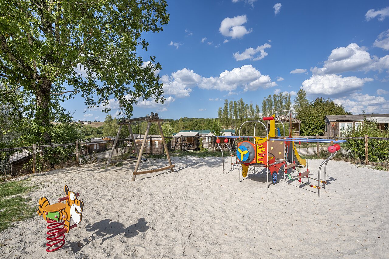 Children's playground, swing set at CAPFUN Ullule campsite in Tournon d'Agenais.