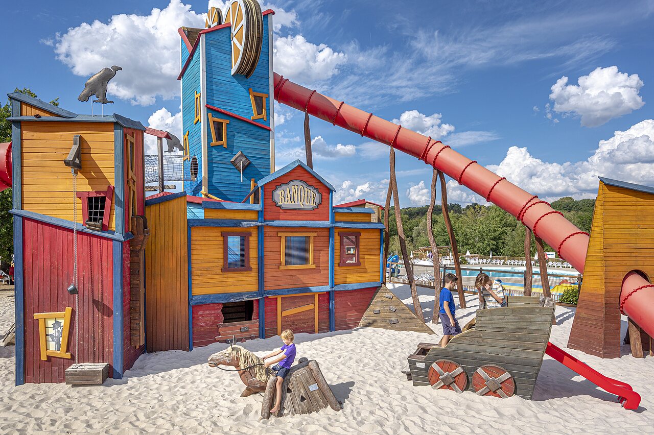 Wild West playground with giant slide and children at CAPFUN Ullule campsite in Tournon d'Agenais (47).