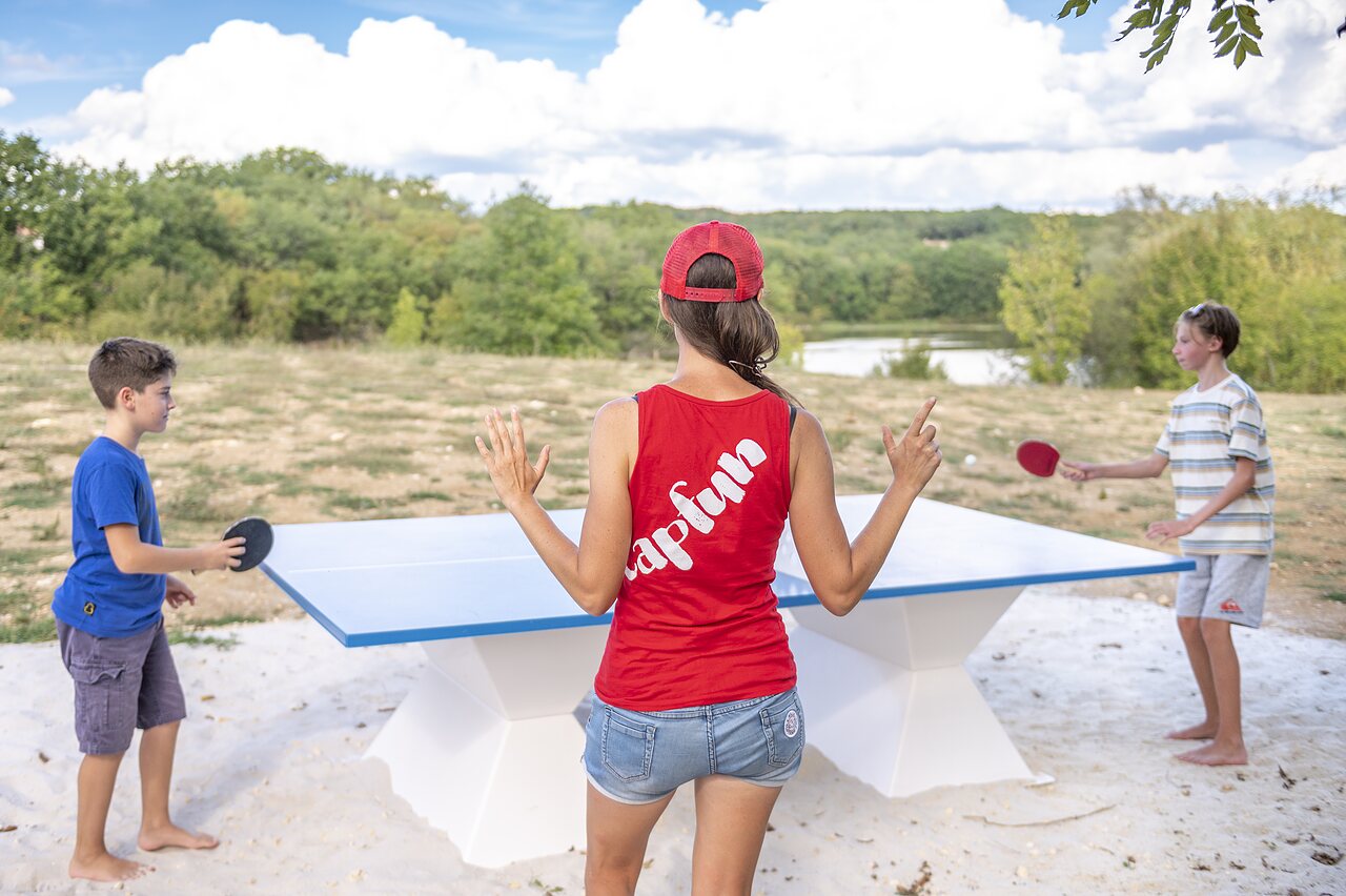 Family playing table tennis on outdoor table at CAPFUN Ullule campsite in Tournon d'Agenais (47).
