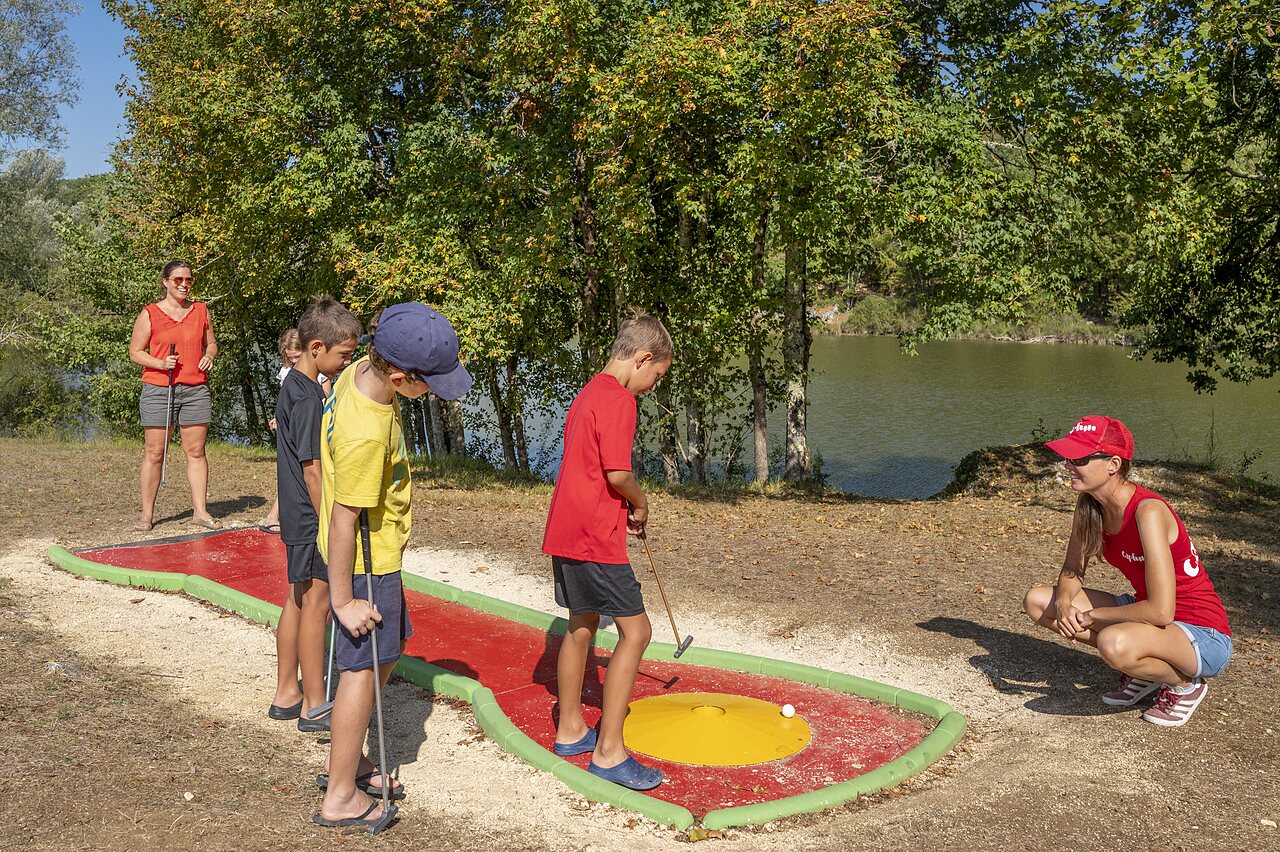 Children playing mini-golf by lake at CAPFUN Ullule campsite Tournon d'Agenais.