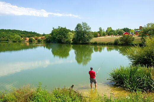 Mann angelt ruhig im See des Campingplatzes CAPFUN Ullule in Tournon d'Agenais (47).