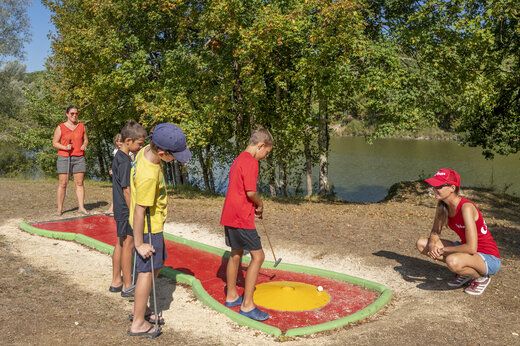 Kinder spielen Minigolf am See auf dem Campingplatz CAPFUN Ullule in Tournon d'Agenais (47).