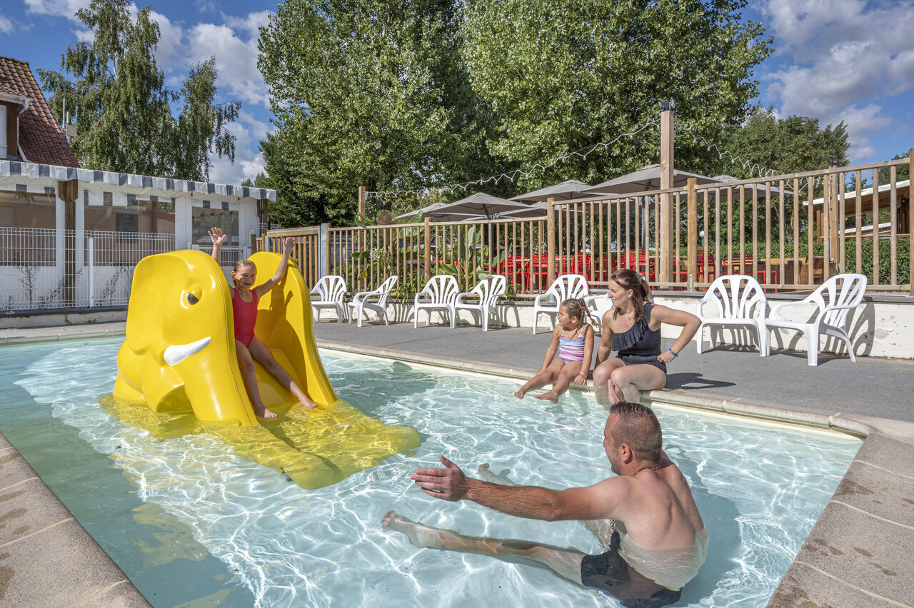Elephant slide and family in the swimming pool at CAPFUN Val d'Authie campsite in Villers sur Authie (80).