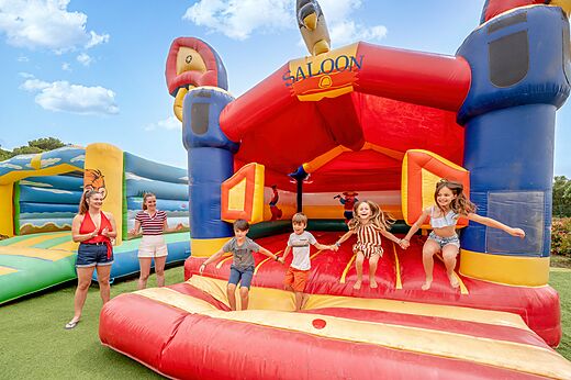 Riesige Hüpfburg und springende Kinder auf dem Campingplatz CAPFUN Vignes d'Or in Serignan.