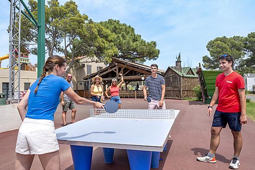 Freunde spielen Tischtennis im Freien auf Camping CAPFUN Vignes d'Or in Serignan.