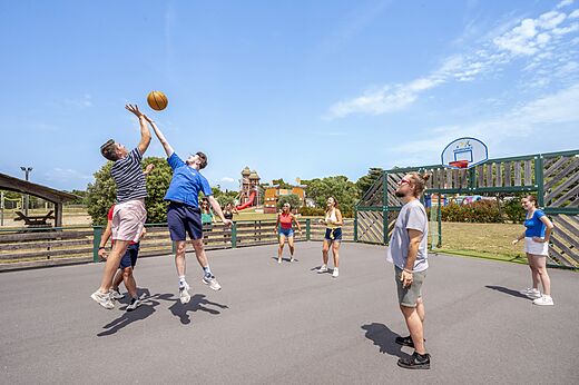 Jugendliche spielen Basketball auf dem Multisportplatz des Campingplatzes CAPFUN Vignes d'Or.
