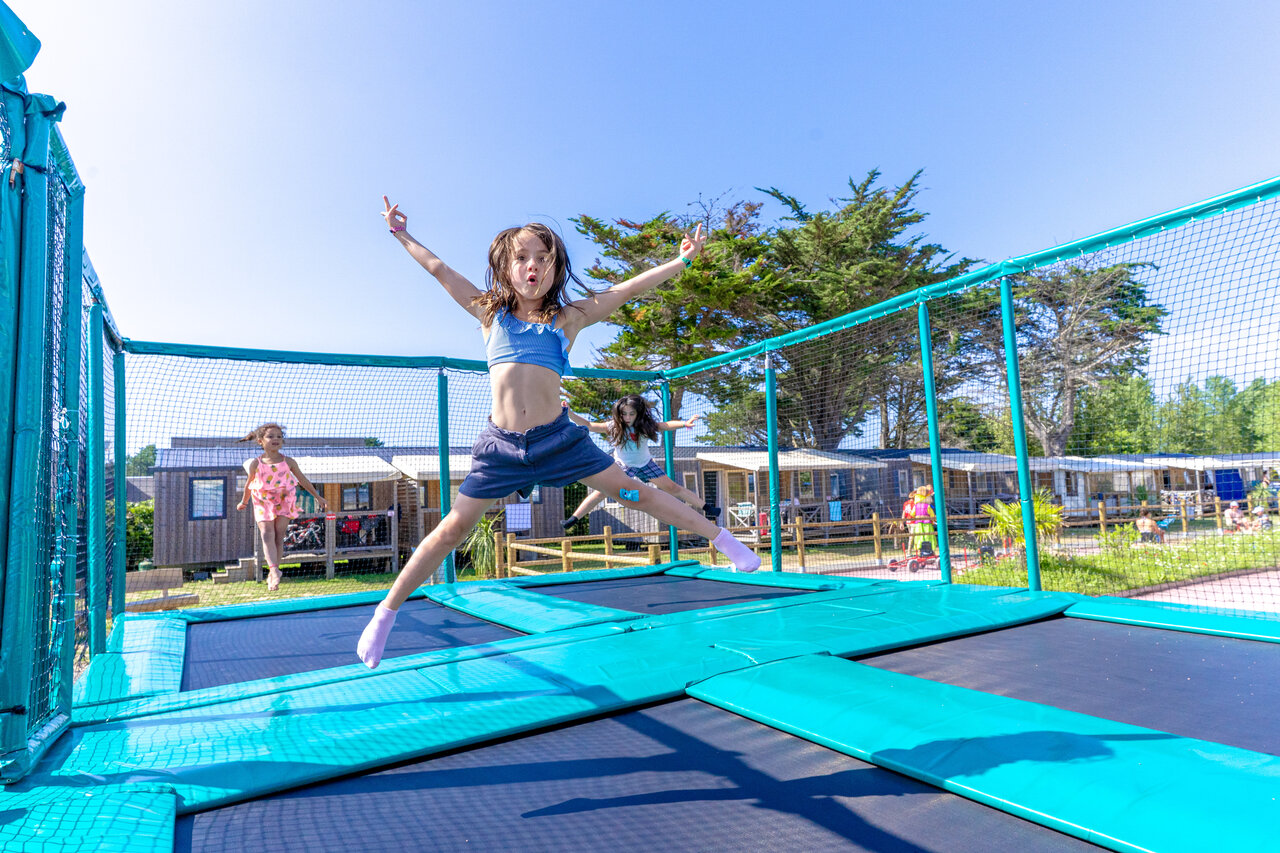 Kinderen springen op trampolines, stacaravans op de achtergrond op camping CAPFUN Vikings in Saint Jean de la Rivi�re (50).