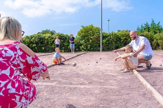Familie speelt jeu de boules op het terrein van camping CAPFUN Vikings in Saint Jean de la Rivière (50).