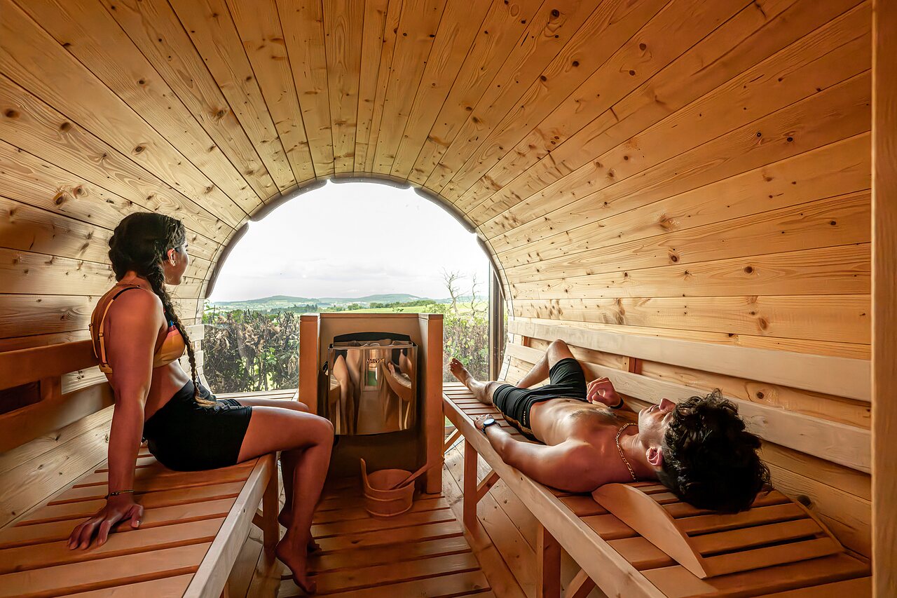 Sauna barril, pareja relaj�ndose en el camping CLICOCHIC Village des Meuniers a Dompierre-les-Ormes.