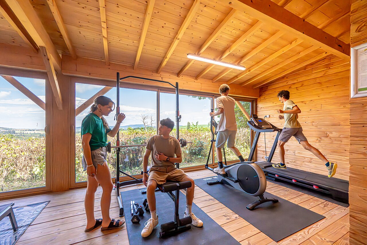 Zona fitness moderna con equipos deportivos en camping CAPFUN Cenic en Dompierre-les-Ormes.