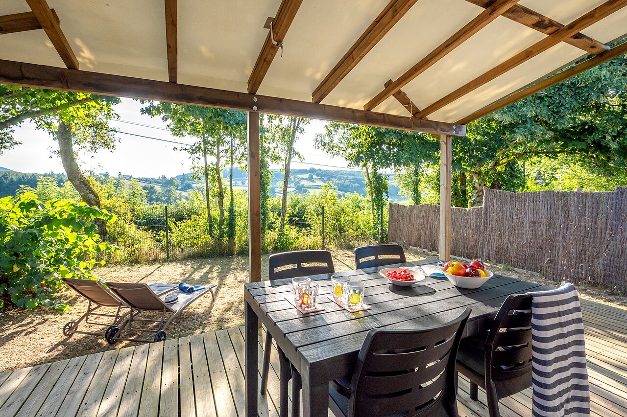 Terraza de Mobil-home con mesa y vista a la naturaleza en el camping CLICOCHIC Village des Meuniers en Dompierre-les-Ormes (71).