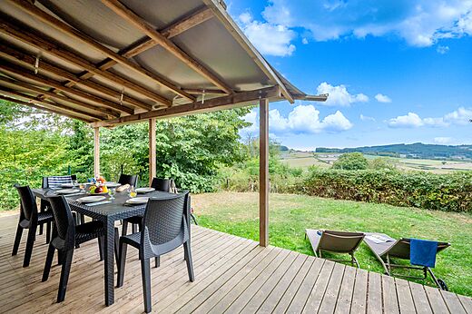 Overdekt terras, tafel en panoramisch uitzicht op camping CLICOCHIC Village des Meuniers in Dompierre-les-Ormes (71).