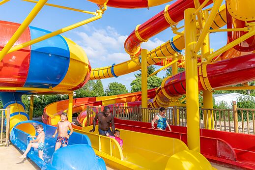 Bunte Wasserrutschen und Wasserspiele auf dem Campingplatz CAPFUN Le Village Parisien.