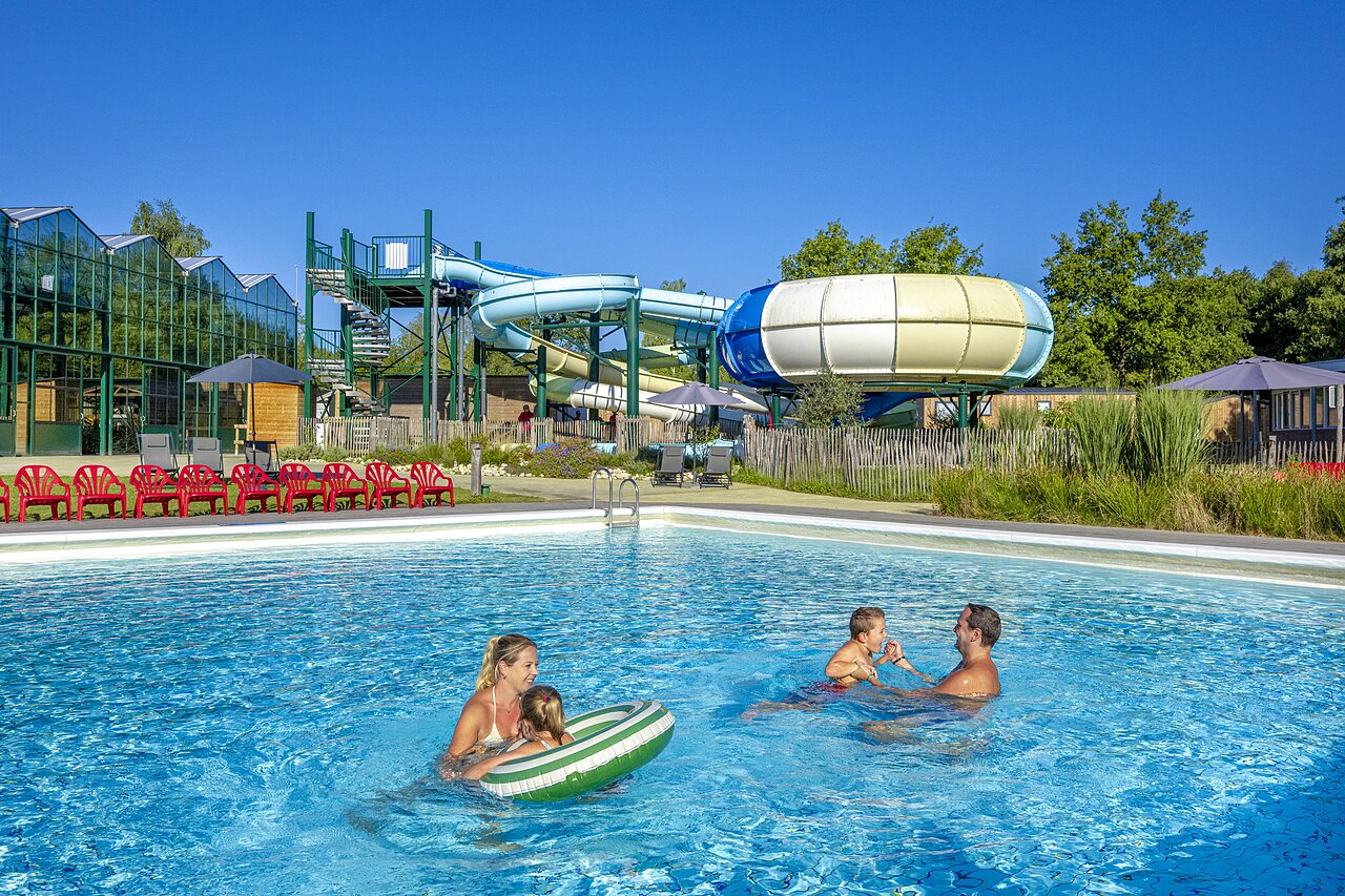 Familie genie�t das Freibad mit Wasserrutschen auf dem Campingplatz CAPFUN Vlinderloo in Enschede.