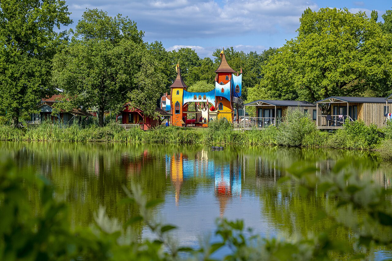 Bunter Burgspielplatz, Mobilheime und See auf dem Campingplatz CAPFUN Vlinderloo in Enschede.