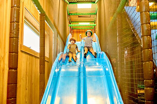 Indoor-Spielplatz mit Rutsche und Kindern auf dem Campingplatz CAPFUN De Waldsang in Bakkeveen
