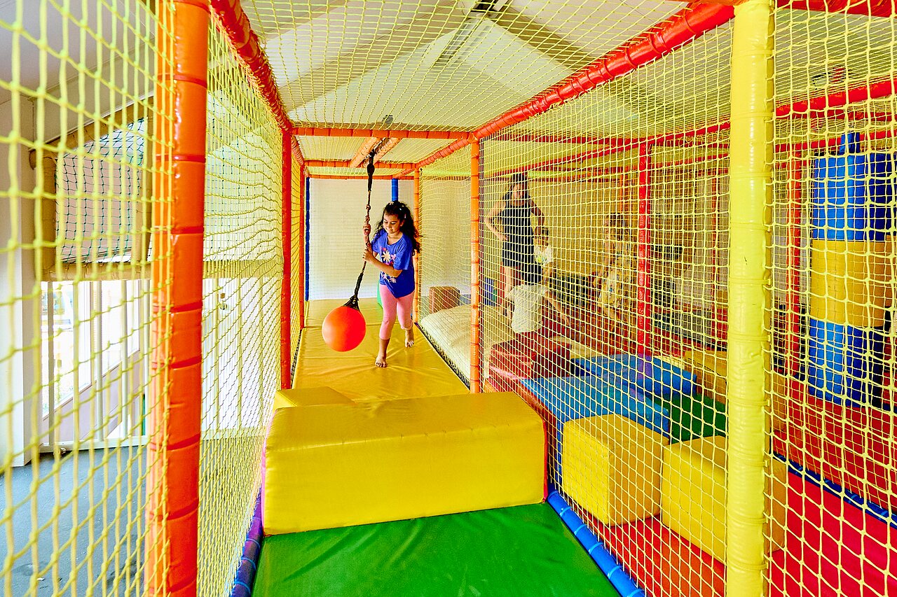 Farbenfroher Indoor-Spielplatz mit spielendem Kind, auf dem Campingplatz CAPFUN Wieskamp in Winterswijk Henxel.