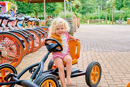 Kleinkind auf Tret-Gokart, Fahrräder auf dem Campingplatz CAPFUN Wieskamp in Winterswijk Henxel.