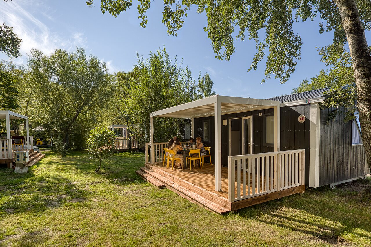 Mobil-home moderne avec terrasse et famille attabl�e au camping CAPFUN het Winkel � Winterswijk.