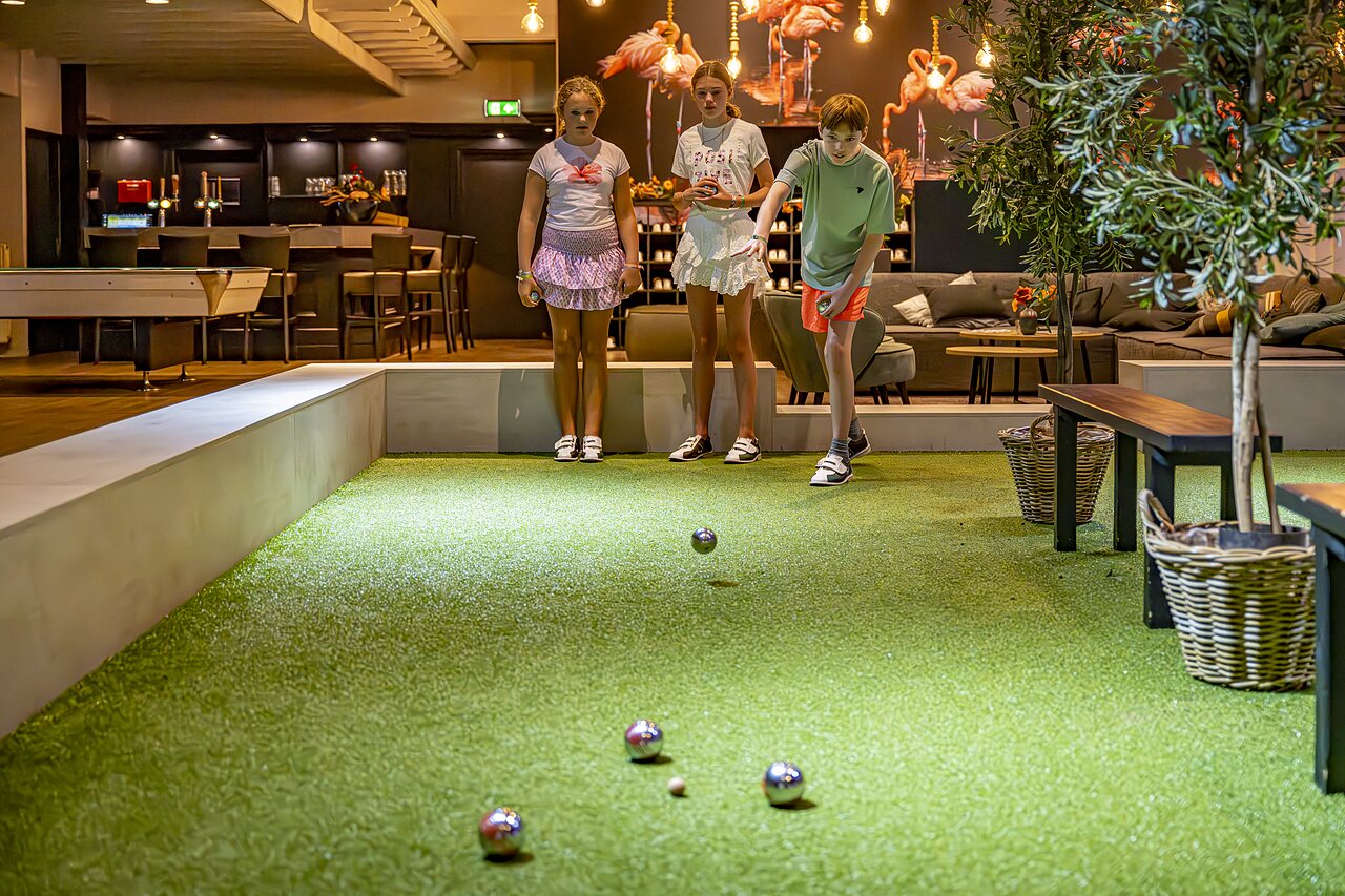 Enfants jouant � la p�tanque sur terrain int�rieur au camping CAPFUN het Winkel � Winterswijk.