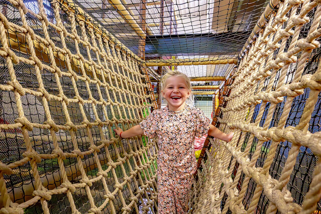 Jeune fille souriante dans un parcours de cordes au camping CAPFUN het Winkel � Winterswijk.