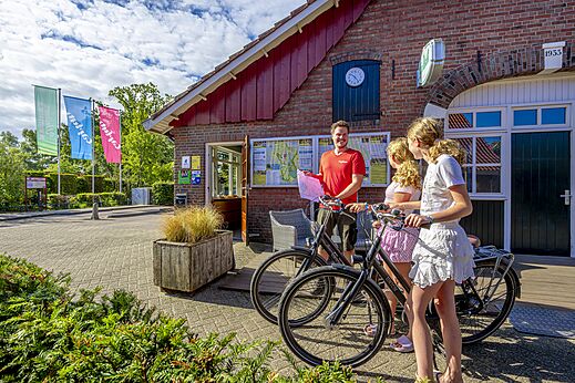 Rezeption des Campingplatzes mit Personal und Radfahrern auf dem Campingplatz CAPFUN het Winkel in Winterswijk.