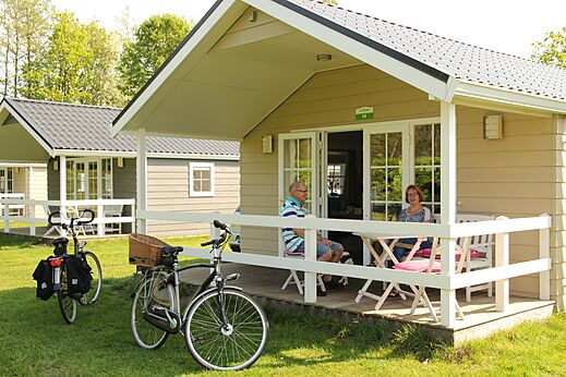 Mobilheim mit Paar auf Terrasse, Fahrräder, Campingplatz CAPFUN het Winkel Winterswijk.
