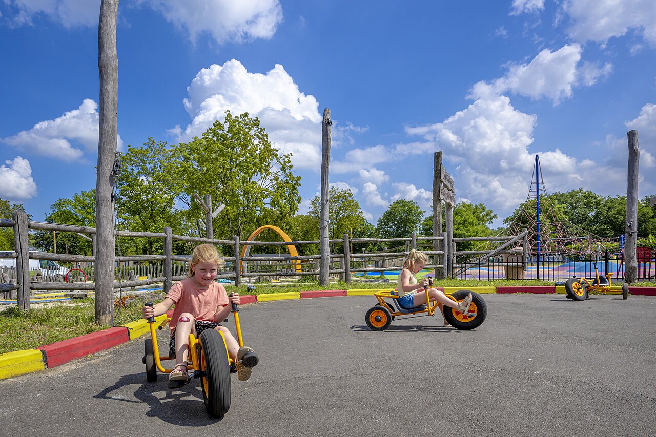 Zwei Kinder auf Tret-Karts auf einer Bahn auf dem Campingplatz CAPFUN de Wondermolen in Molenschot.