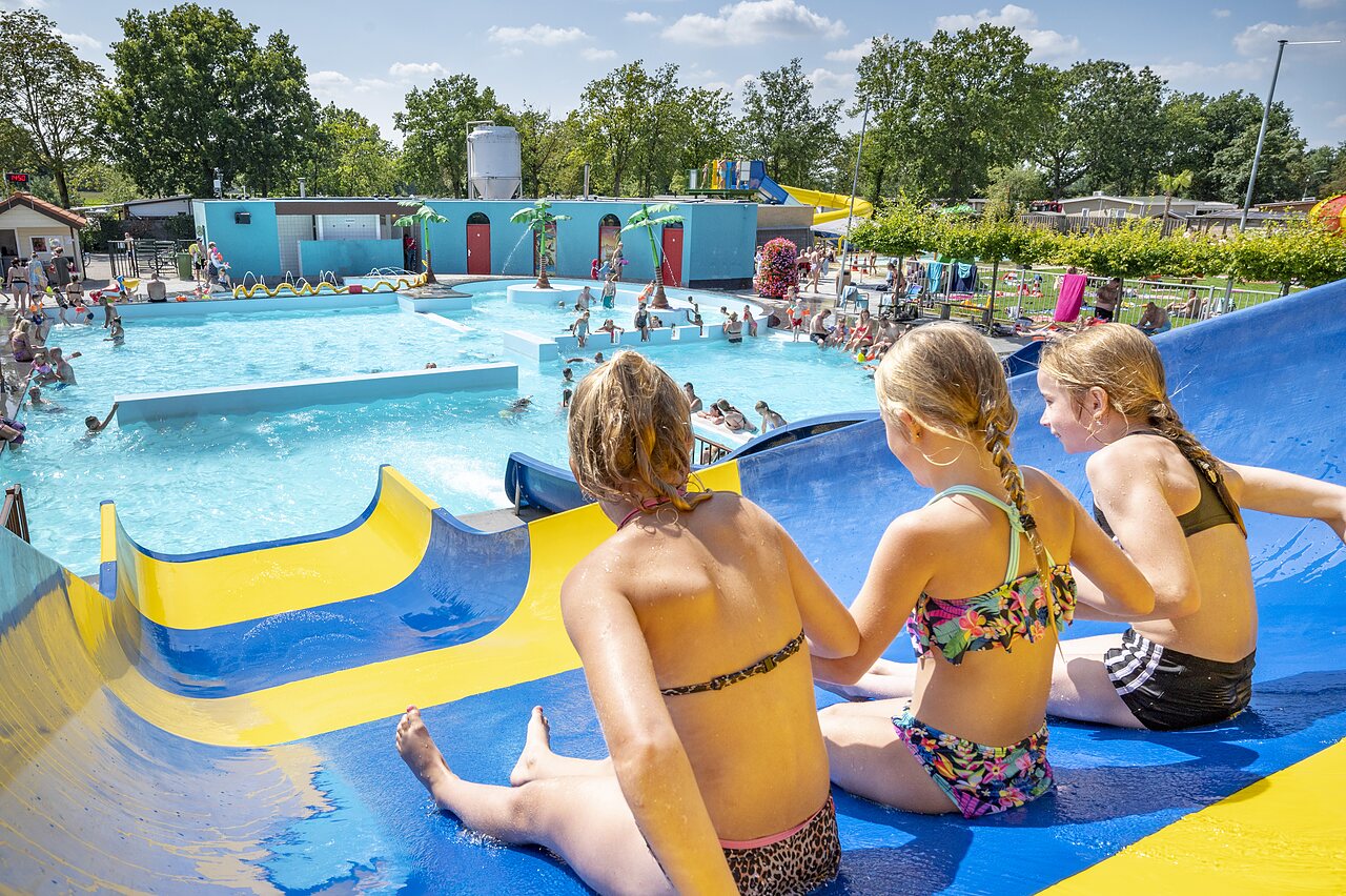 Kinder auf Wasserrutsche, belebtes Freibad auf dem Campingplatz CAPFUN de Wondermolen in Molenschot.