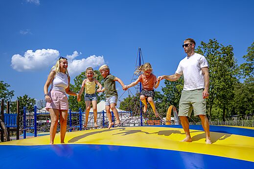 Familie hat Spa� auf dem gro�en H�pfkissen auf dem Campingplatz CAPFUN de Wondermolen in Molenschot.