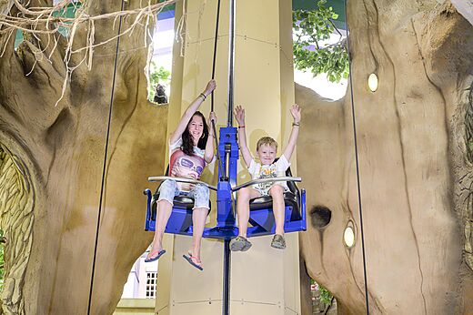 Mutter und Kind l�chelnd auf einer Indoor-Spielattraktion auf dem Campingplatz CAPFUN de Wondermolen in Molenschot.
