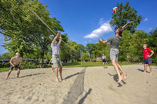 Sand-Beachvolleyballfeld mit Spielern auf dem Campingplatz CAPFUN Wondermolen in Molenschot.
