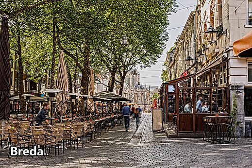 Lebhaftes Stadtzentrum von Breda mit Terrassen und historischer Kirche, Niederlande.