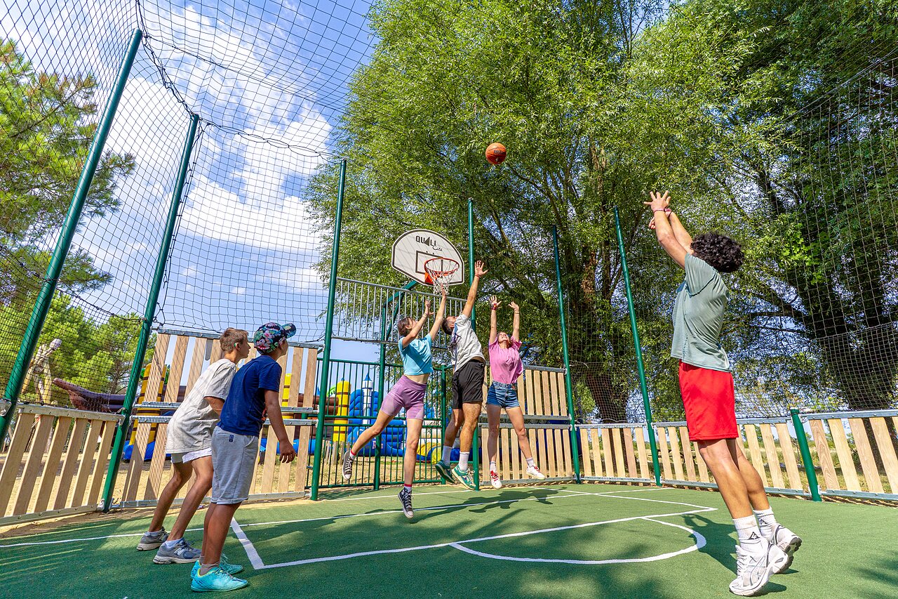 Jugendliche spielen Basketball auf Multisportplatz auf dem Campingplatz CAPFUN Zagarella in LONGEVILLE SUR MER (85).