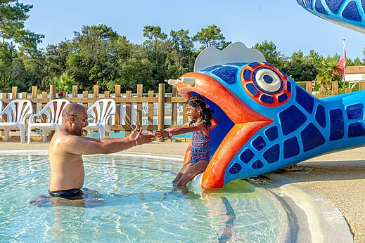 Kind rutscht von Fisch-Wasserrutsche im Pool bei CAPFUN Zagarella in LONGEVILLE SUR MER (85).